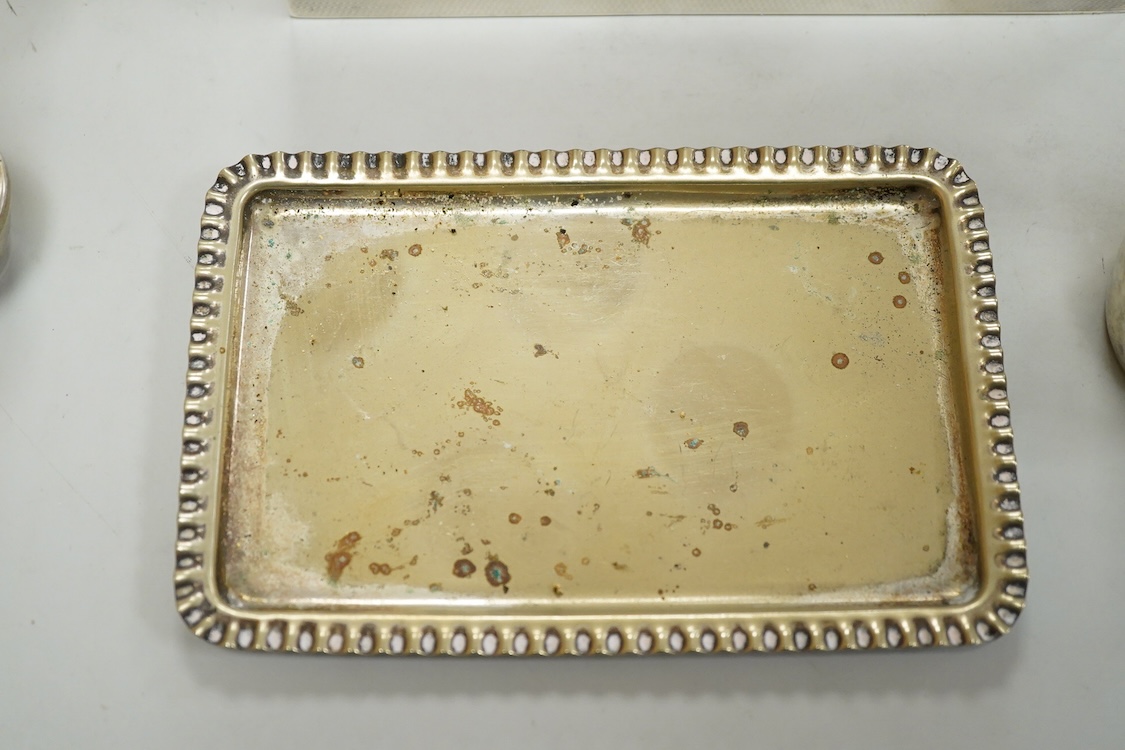 A George V engine turned silver mounted rectangular cigarette box, Birmingham, 1923, 17.7cm, a sterling mounted pepper grinder, four weighted sterling condiments and a small plated tray.